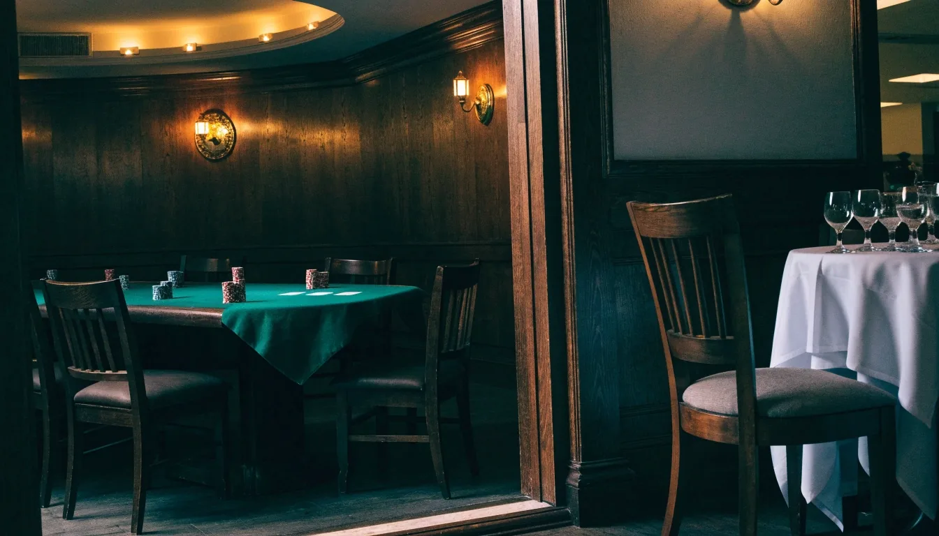 Široký interiér restaurace s dlouhými stoly a teplým světlem večer